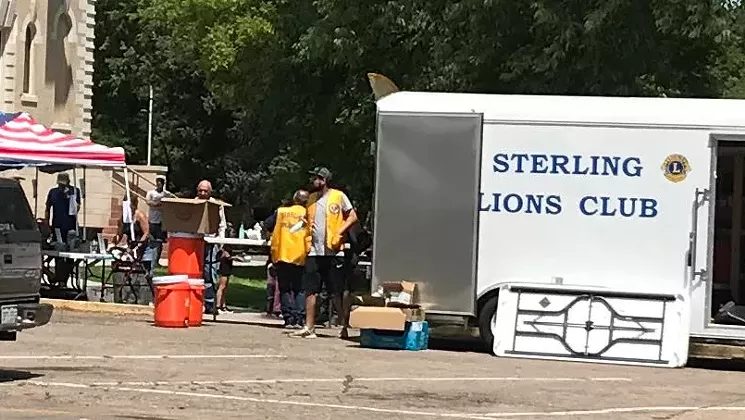 Masks weren't much in evidence among the folks working the booths at the Sterling Lions Club anniversary bash. - PHOTO BY MICHAEL ROBERTS