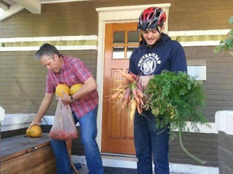 Volunteers pick up donated food from a porch. - FRESH FOOD CONNECT