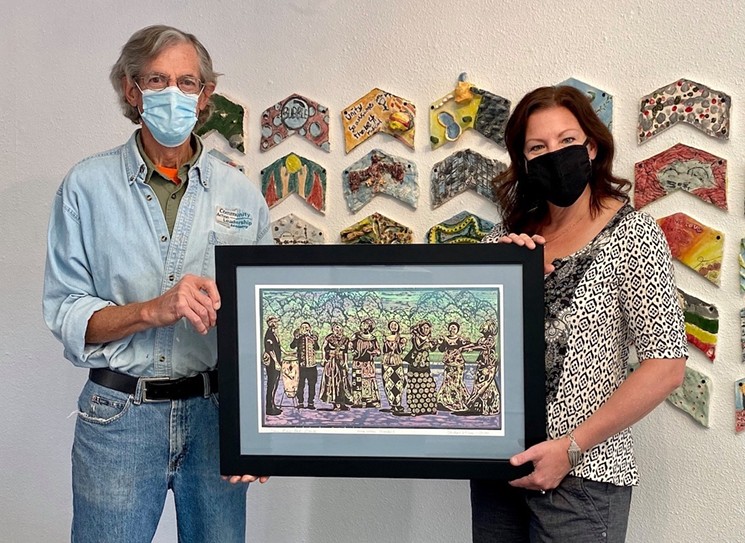 DAVA resident artist Michael Keyes shows off his woodcut print inspired by the Congolese Gloria Choir performance held at DAVA last summer. - COURTESY OF DAVA