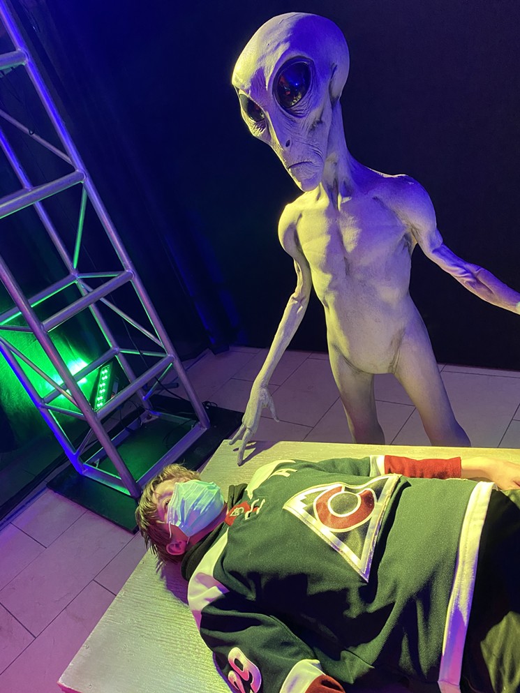 A Roswell alien dissects a guest in a photo op at Distortions Monster World. - DISTORTIONS MONSTER WORLD