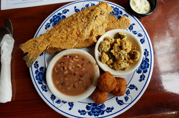 fried catfish on a plate with beans, fried okra and hushpuppies
