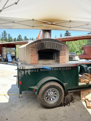 A whole lot of pizzas have already been cooked in this mobile wood-fired oven. - MOLLY MARTIN