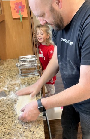 Sophie smiles while Rosenberg makes pasta at home. - SOPHIE'S NEIGHBORHOOD