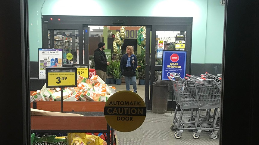 King Soopers managers looking at picketers through the locked front doors of a southwest Jeffco store before opening time on January 12. - PHOTO BY MICHAEL ROBERTS