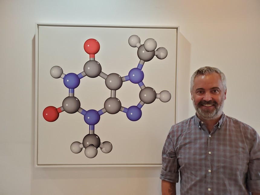 Phil Simonson, owner of Chocolate Lab, stands in front of an image of the chocolate molecule. - MOLLY MARTIN