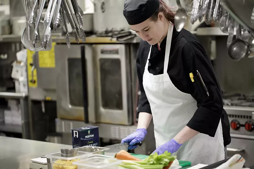 A student prepares vegetables for the school's annual soup giveaway, which happens on Emily Griffith's birthday every February. - EMILY GRIFFITH
