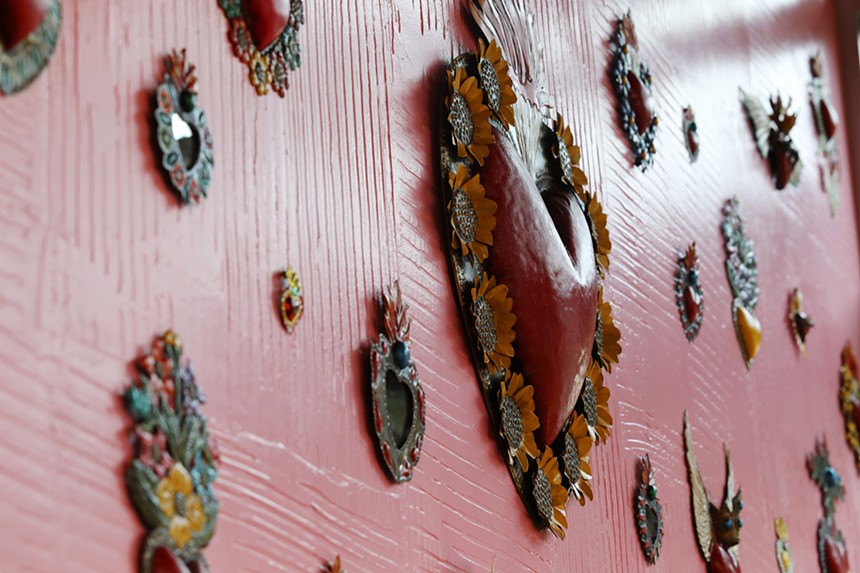 Dozens of tin hearts made by a family friend of the Aragons adorn the wall above the counter. - TOM HELLAUER