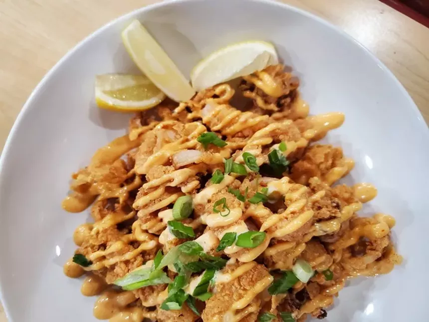 fried calamari on a plate with lemon slices
