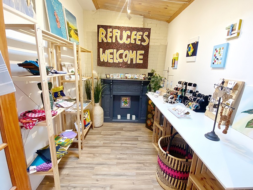 a sign reads refugees welcome inside a shop