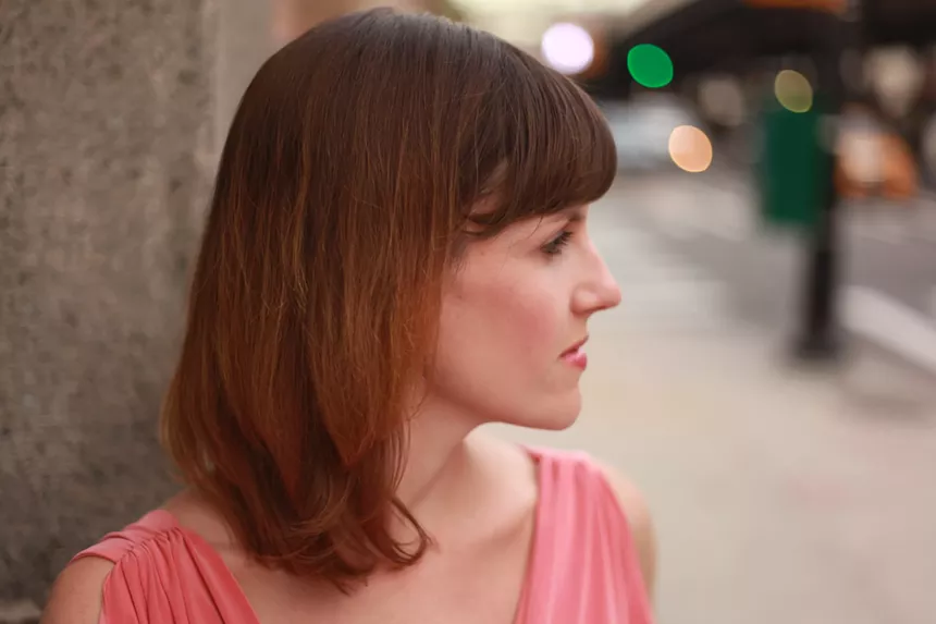 redhaired woman's profile in pink shirt