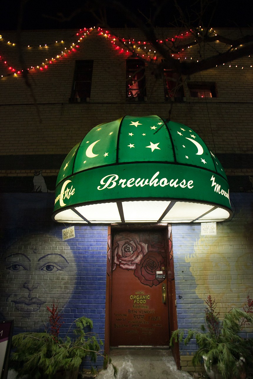 the mercury cafe in denver's green awning with moons and stars and mural of the moon and sun
