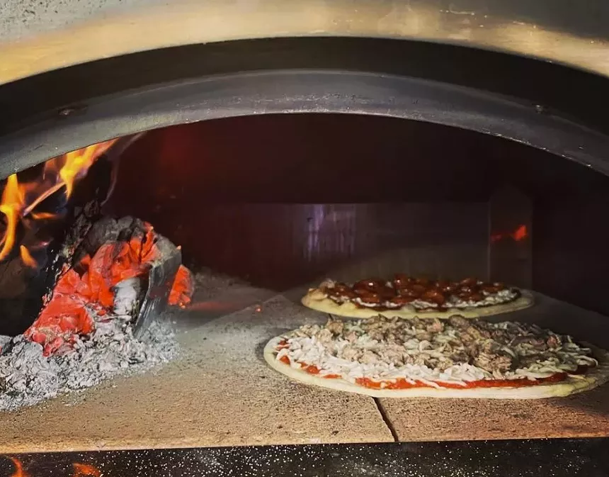 pizza cooking in a wood fired over