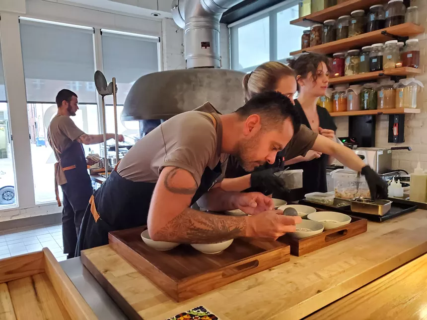 chefs in aprons plating dishes at a restaurant