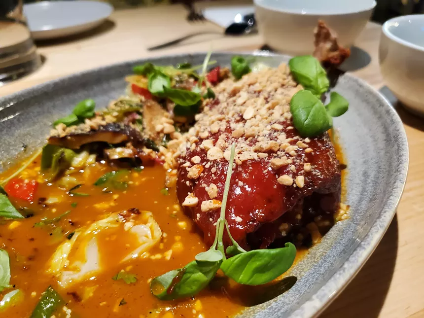 a duck leg in an orange sauce