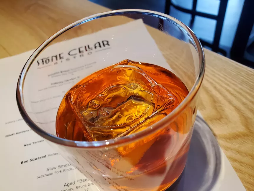 a red-hued cocktail in a clear glass