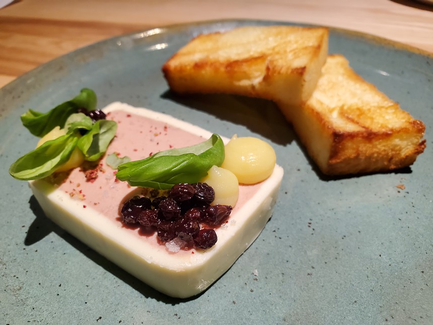 a slice of foie gras with currants, basil and lemon curd on top