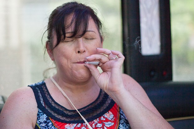 A woman smokes a joint on a mobile cannabis lounge