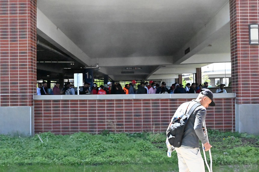 Un grupo de migrantes esperando en el garaje de 5th Street en el campus de Auraria en Denver, Colorado.