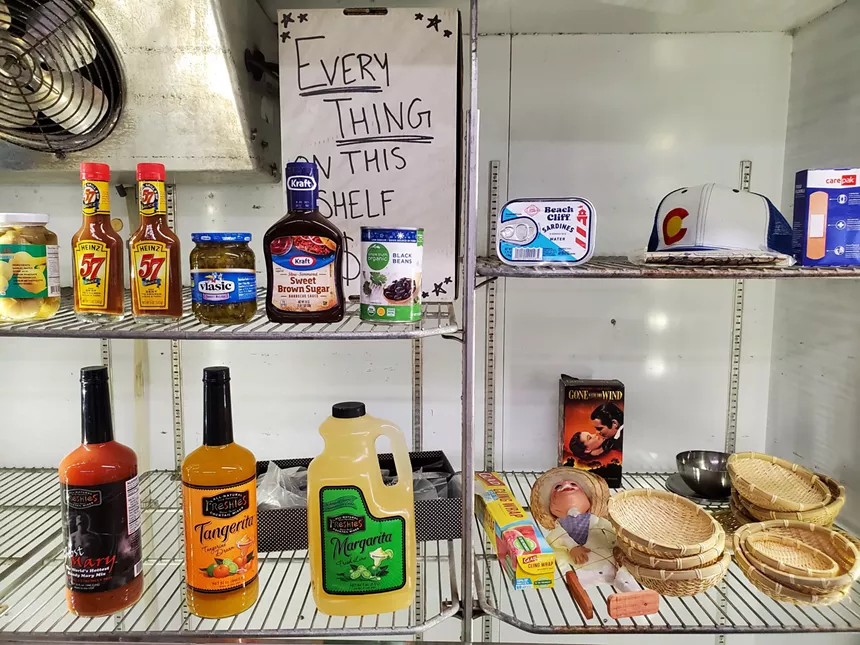 canned beans, steak sauce and other items on a bare shelf in a store