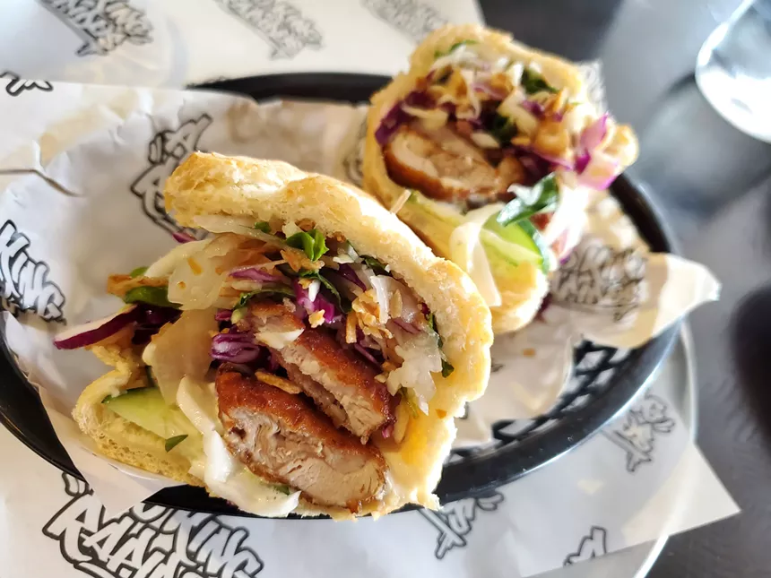 a chicken sandwich on a soft roll with cabbage slaw