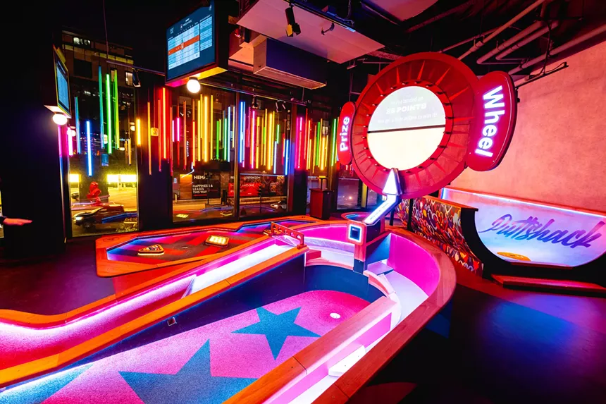 a hole at an indoor mini golf course with lots of bright colors