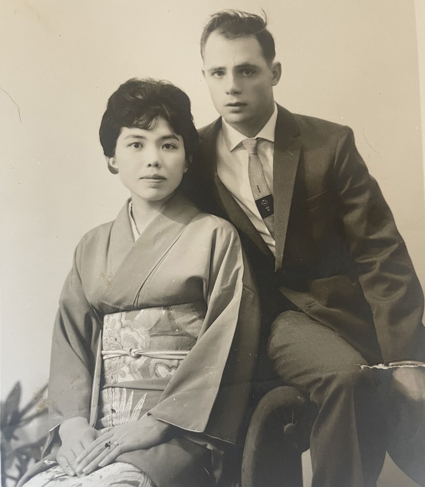 A woman in a kimono and man dressed in a suit sit next to each other.