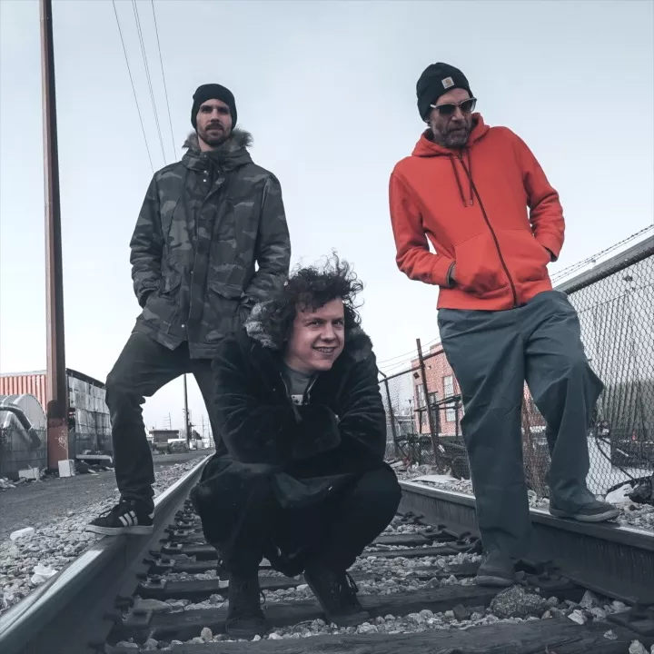 three men posing on train tracks
