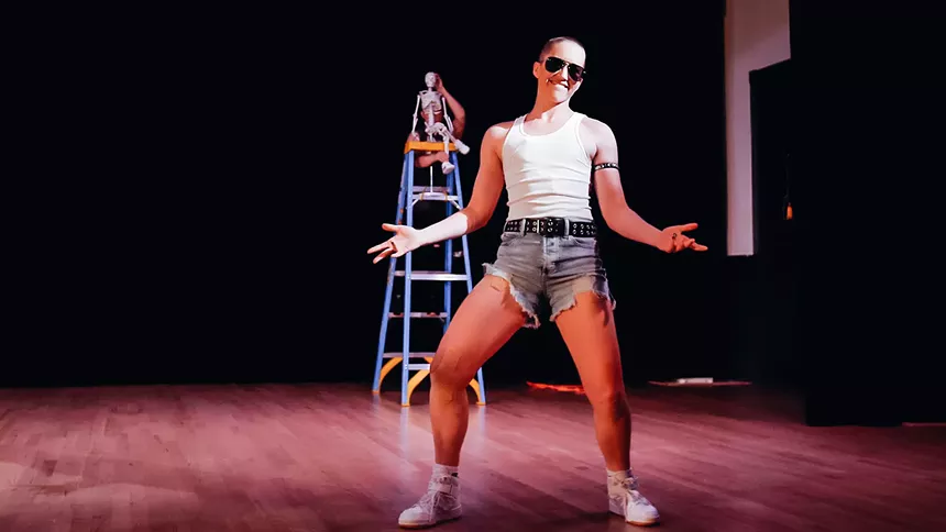 a woman dancing in sunglasses and jean shorts