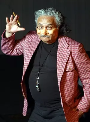 a man in a pink jacket striking a silly pose