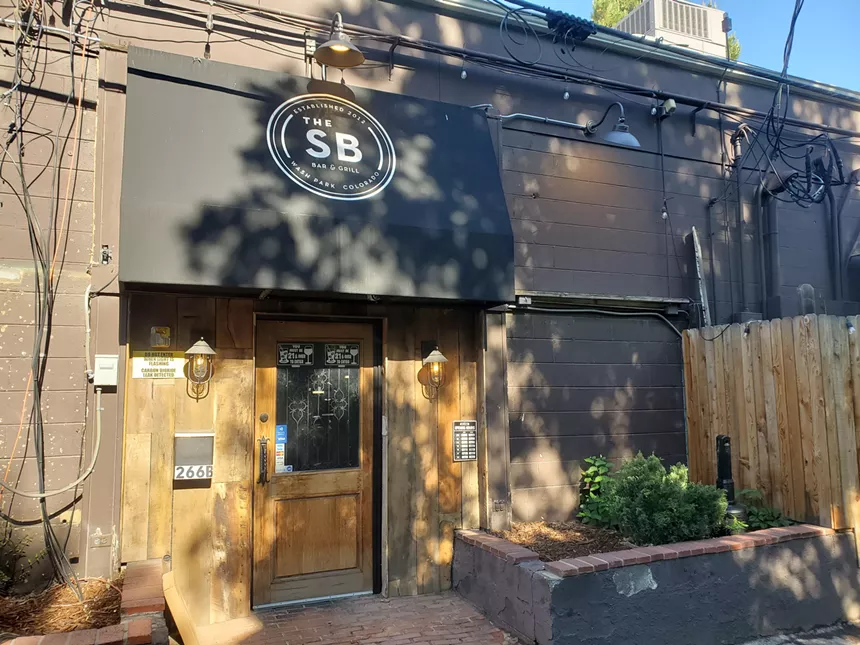 a brown building with a black awning
