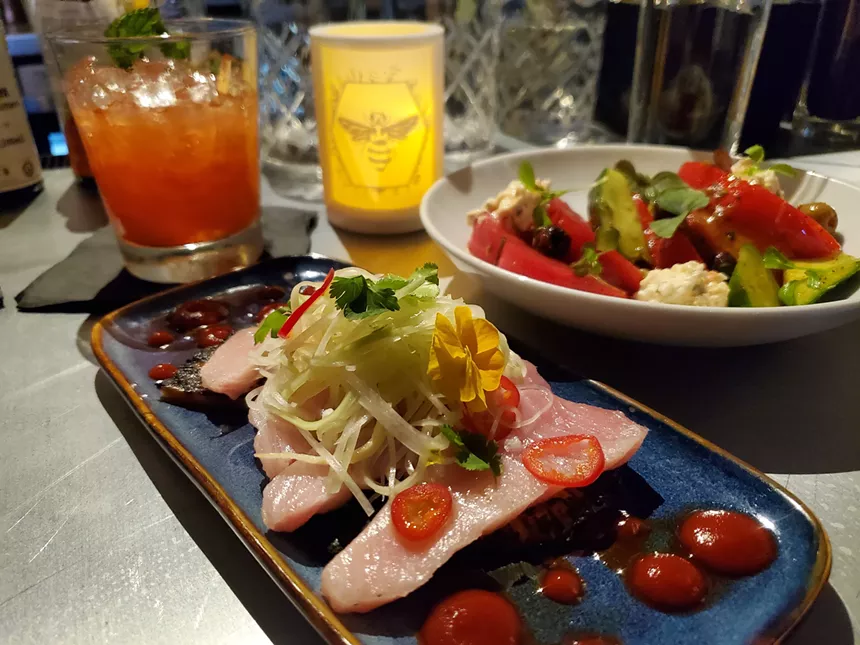 slices of tuna on a plate topped with chiles and salad