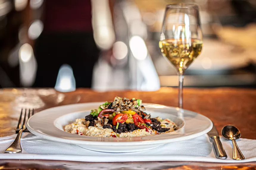a plate of food and a glass of wine on a table