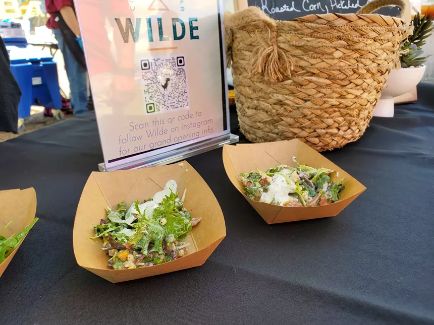 two salads in cardboard bowls