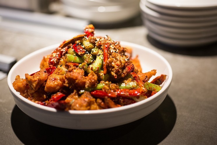 a bowl of fried chicken with whole chile peppers