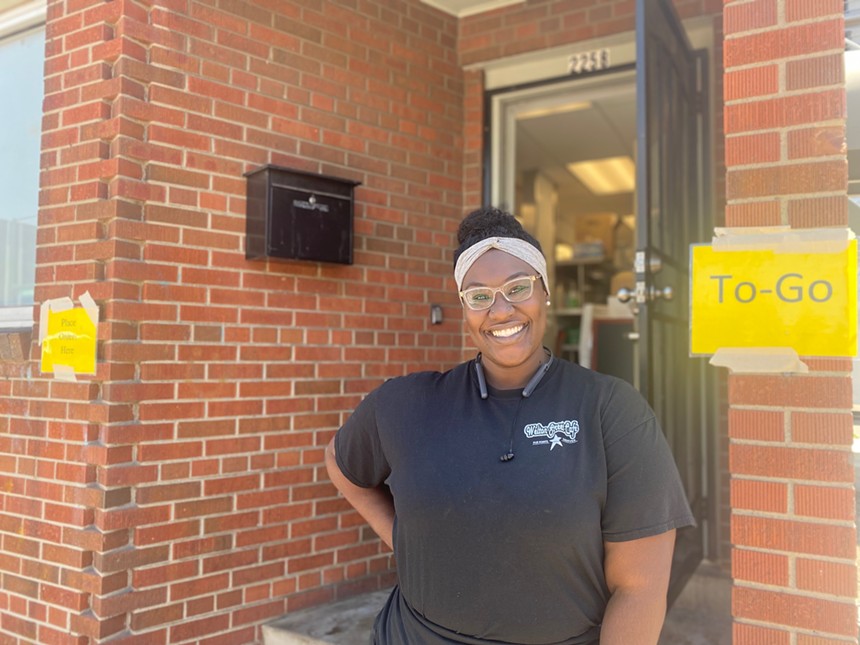 Woman with big smile stands near door in building