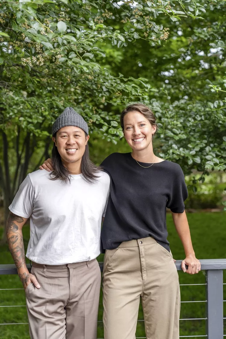 a man with long hair and a beanie next to a woman in a black t shirt