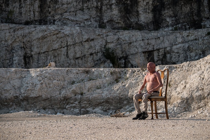 man sitting in chair on italian beach