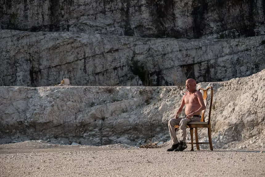 man sitting in chair on italian beach
