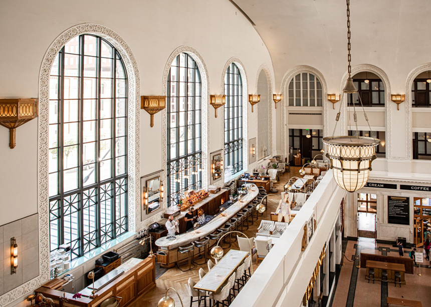 a big room with white walls, large windows and a marble-topped bar