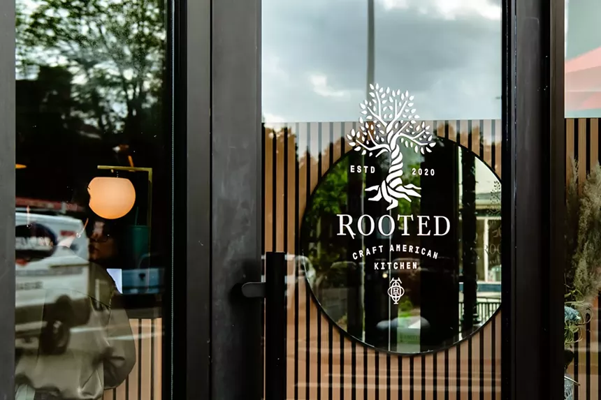 a glass entryway with a black sign in the window
