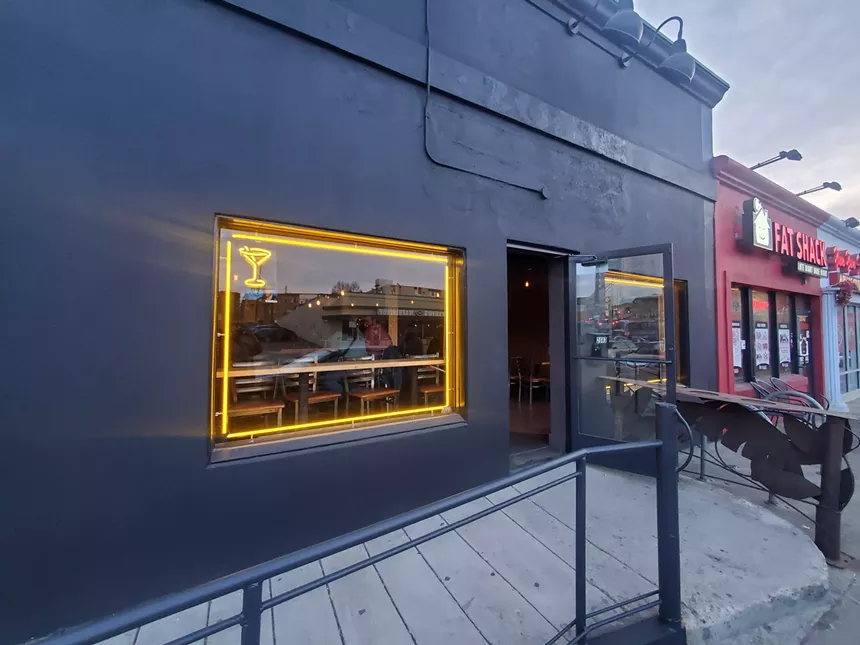 a black building with a window and an open door
