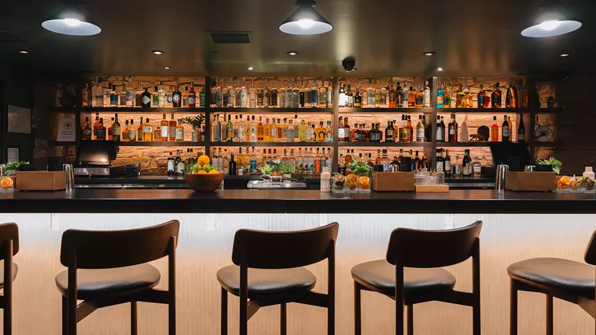 three chars in front of a stocked bar