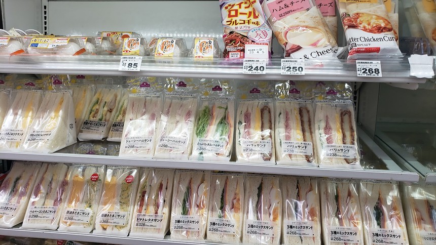 a store refrigerator case filled with packaged sandwiches