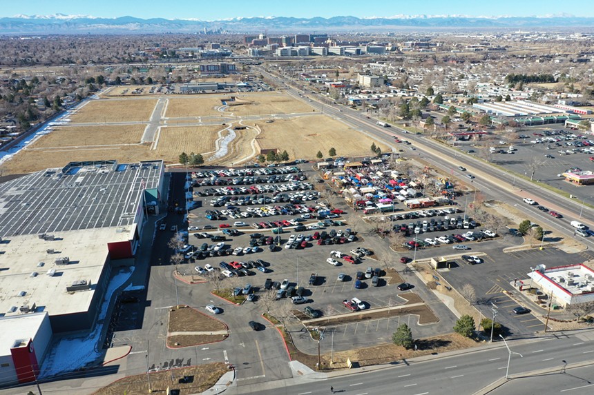 an aerial view of a large building next too a parking lot filled with cars and food trucks