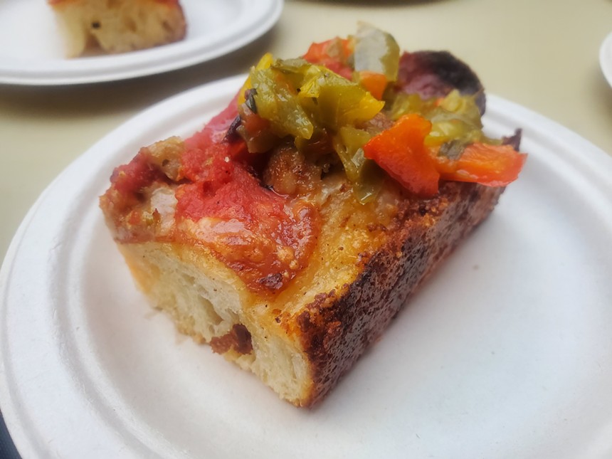a rectangular slice of pizza with pepperoni and peppers