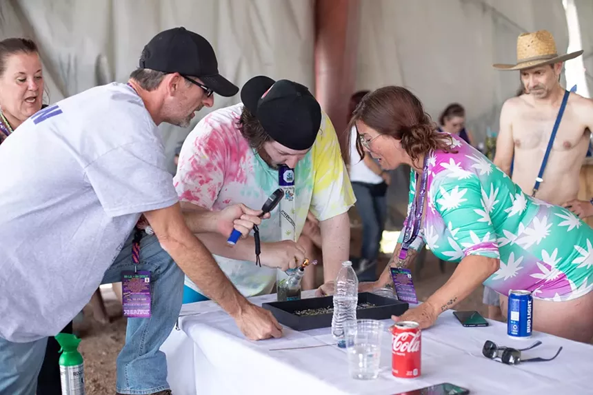 A man takes a hit of cannabis with a magnifying glass