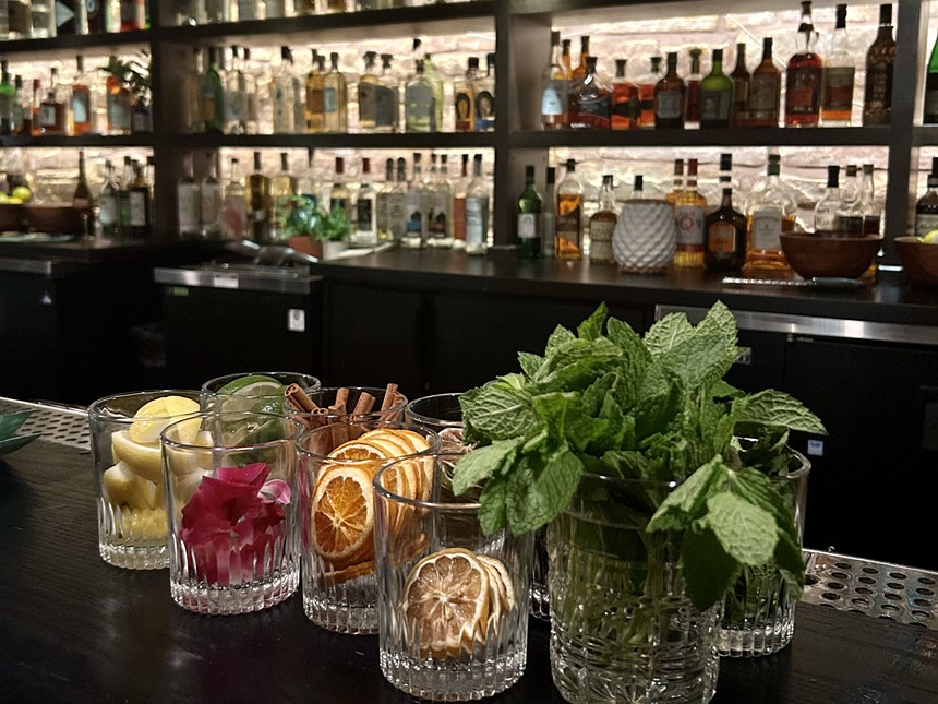 Cocktail garnishes in glasses in front of a bar