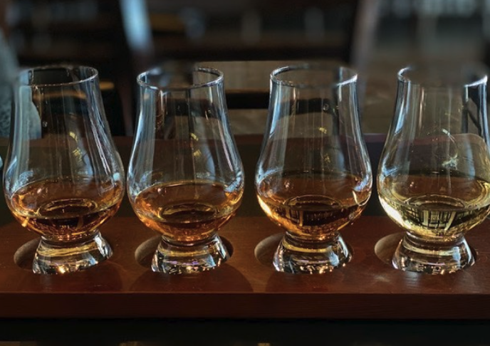 four small glasses on a wooden board