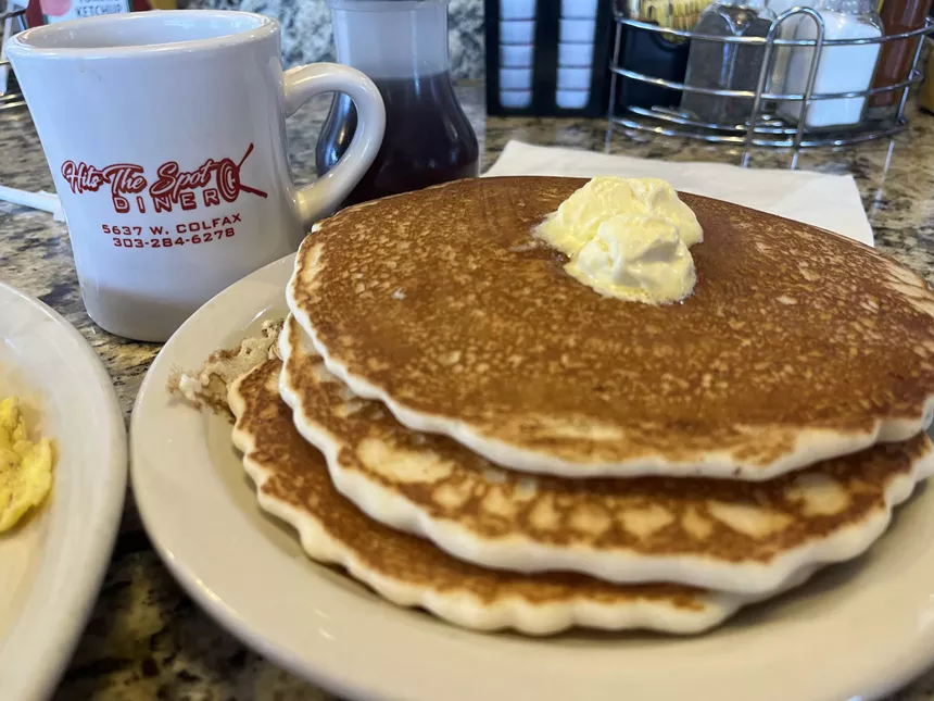 a stack of thr4ee pancakes on a plate with butter on top