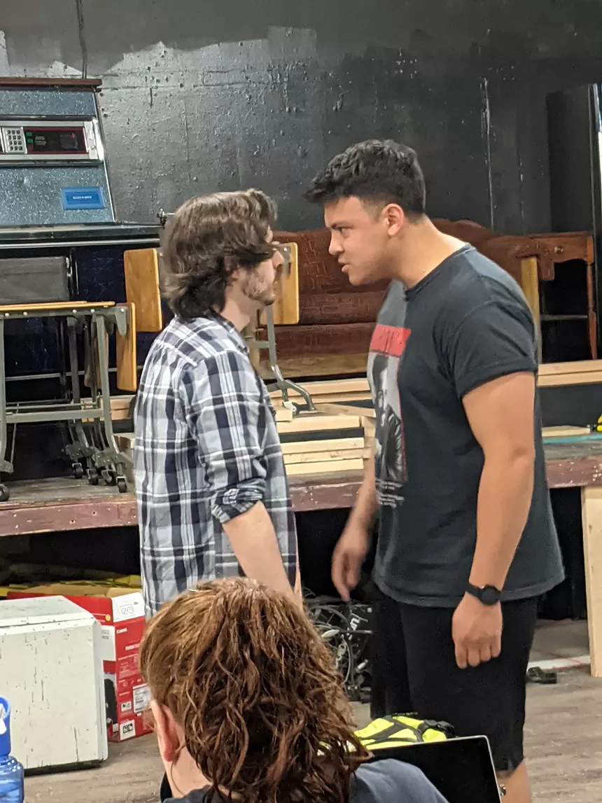two boys arguing with their foreheads almost touching.